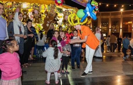 Kids enjoy the colourful creations of a balloon twister at the Carnival